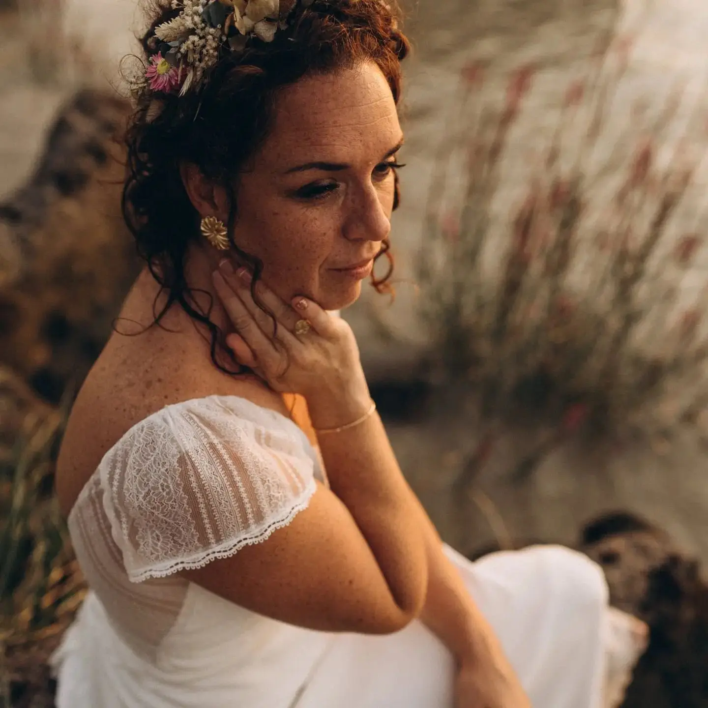 Portrait d’une mariée portant une couronne de fleurs séchées, dans la lumière du soir.
