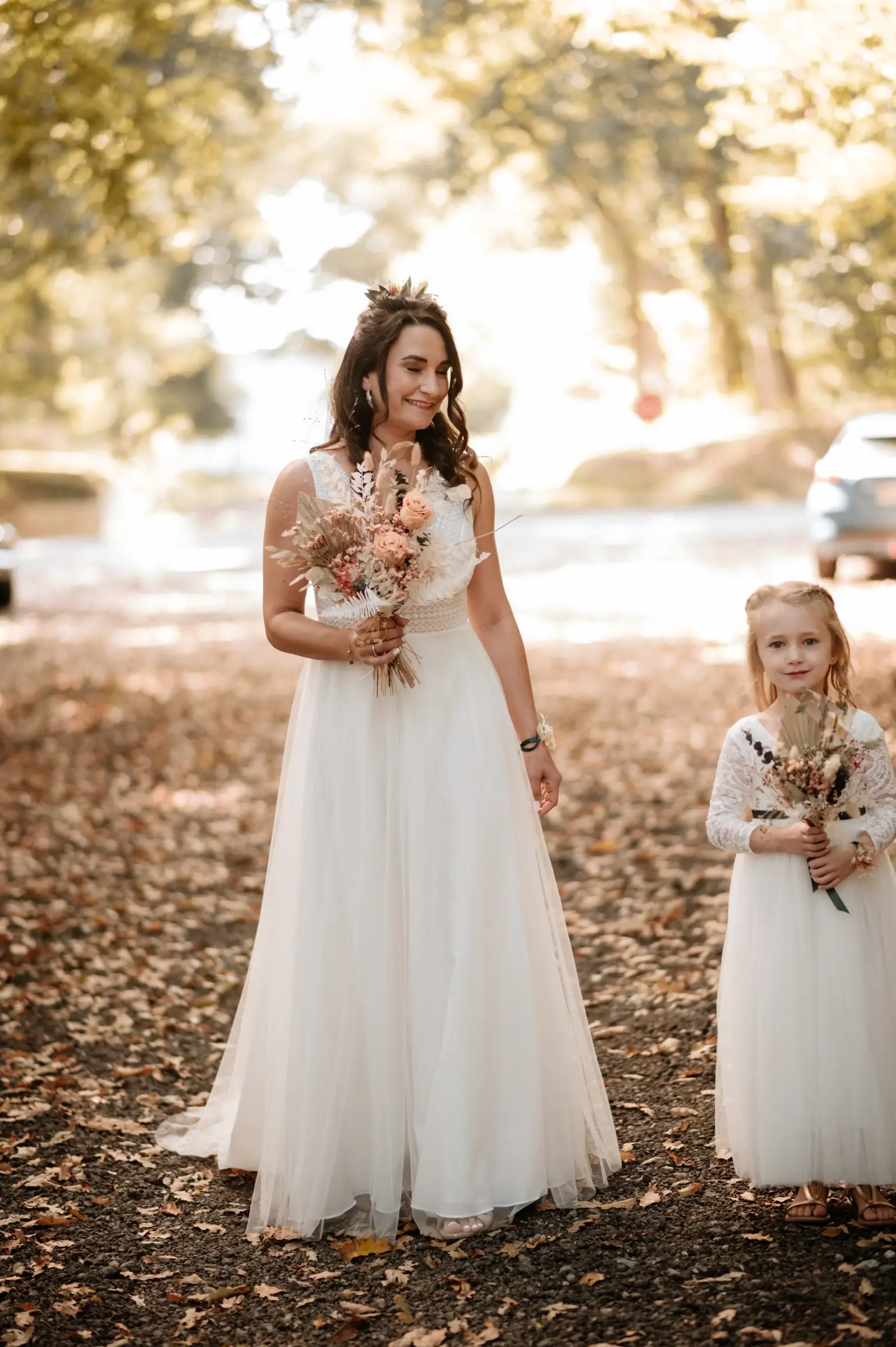 Une mariée et une petite demoiselle d’honneur, chacune avec son bouquet de fleurs séchées.